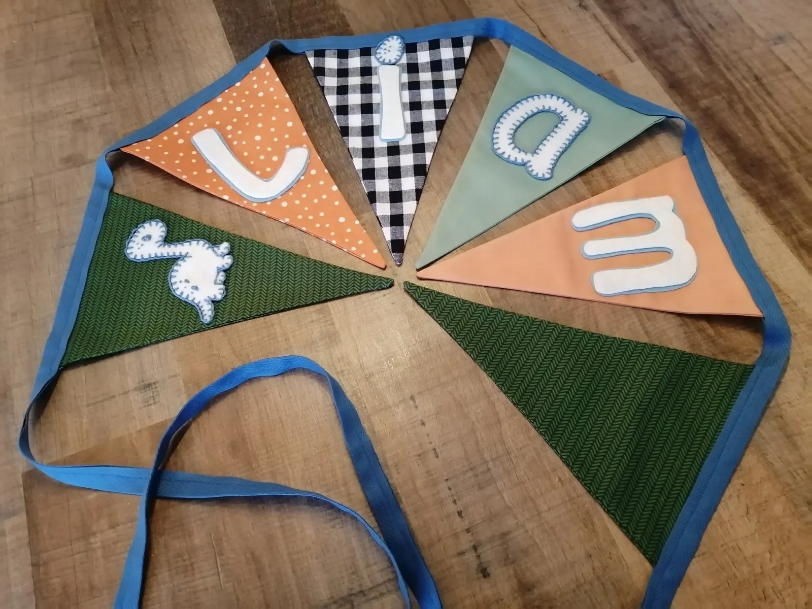 Stoffen naamslinger LIAM in oranje en saliegroen, met een ruitmotief en konijn