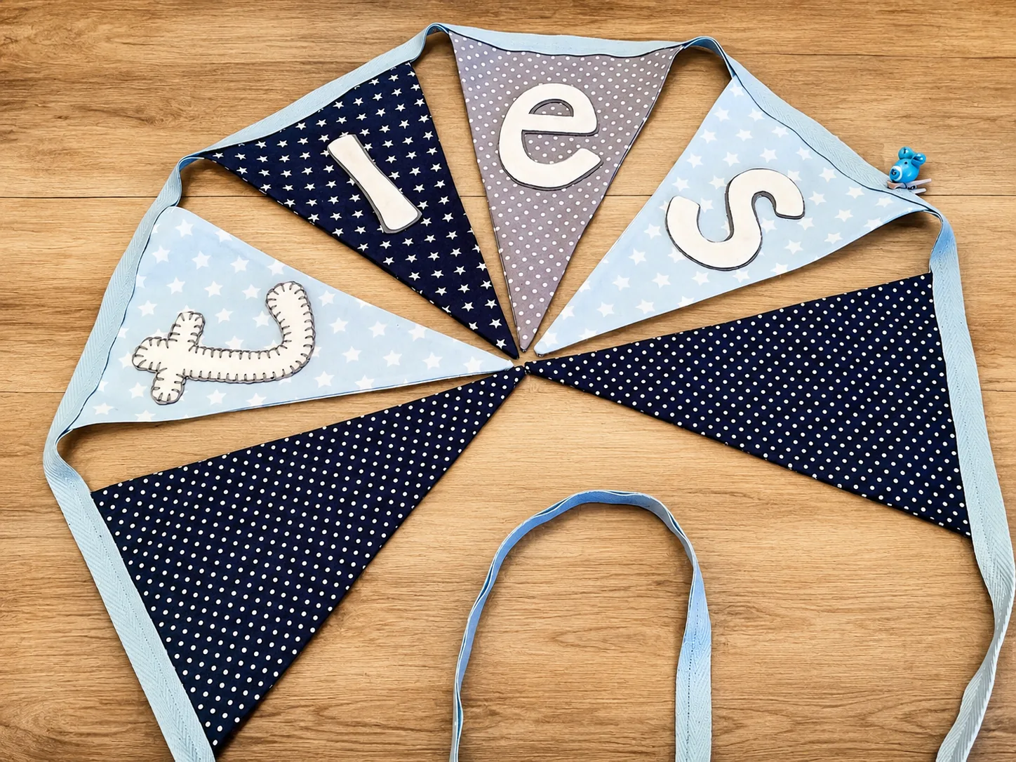 Handgemaakte blauwe stoffen naamslinger op een houten ondergrond